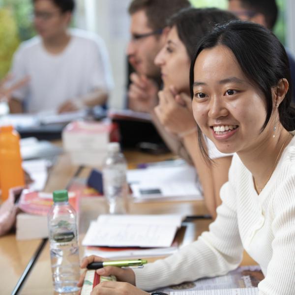 Student smiling whilst discussing a topic in class