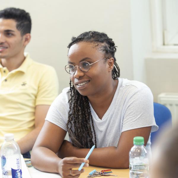 Lady sat listening intently to her teacher, amongst other students